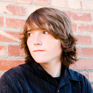 Young kid with medium-length hair over the forehead and ears, looking off camera