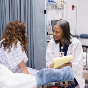 Doctor in a hospital, going over a chart with a young girl